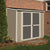 A beige shed with double doors and a lock, located near a brick wall with flowers and mulch in the foreground.  A beige shed with double doors and a lock, located near a brick wall with flowers and mulch in the foreground.