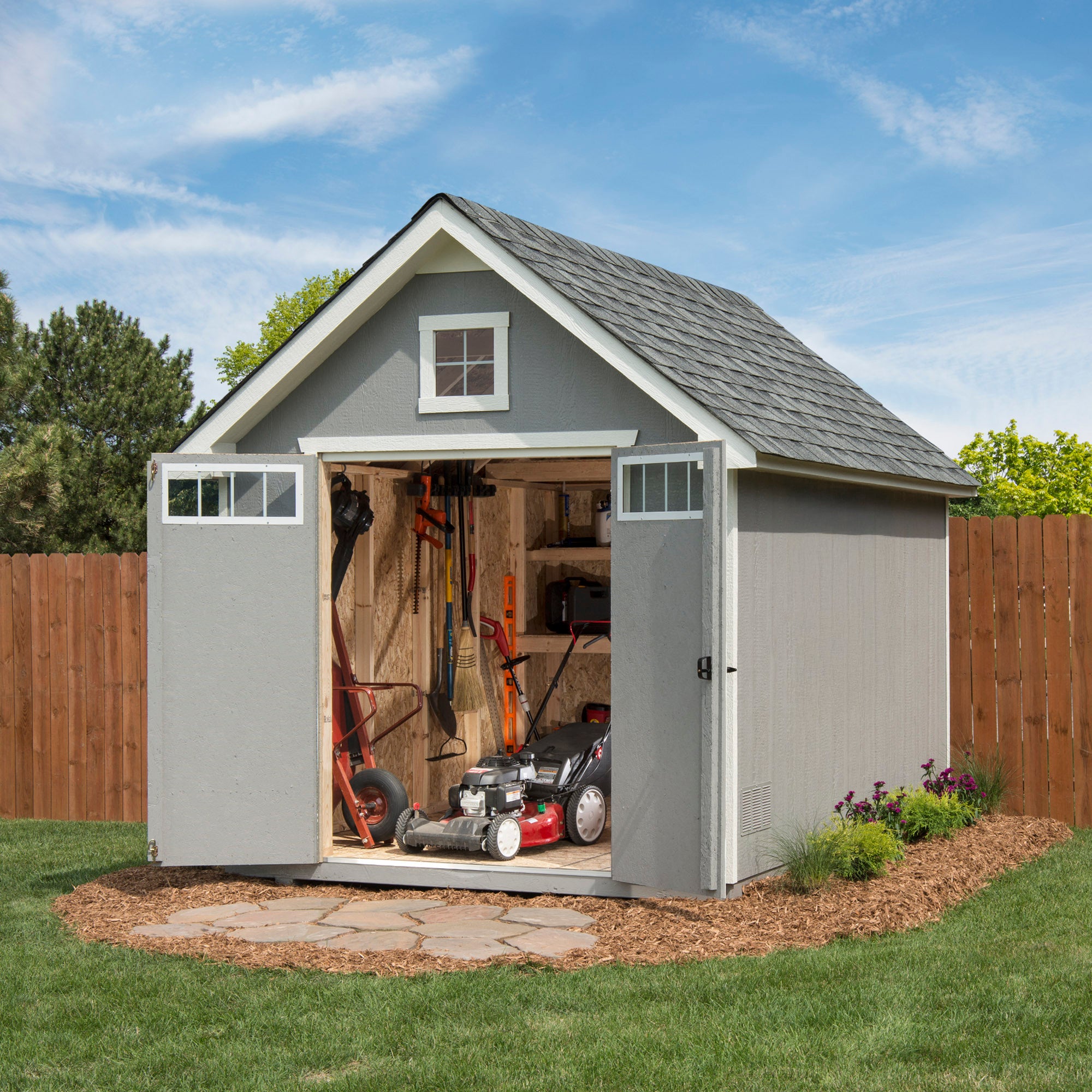 Storage shed with open double doors, revealing organized tools and a lawn mower inside. Storage shed with open double doors, revealing organized tools and a lawn mower inside.