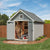 Storage shed with open double doors, revealing organized tools and a lawn mower inside. Storage shed with open double doors, revealing organized tools and a lawn mower inside.