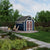 Backyard storage shed with decorative double doors, transom windows, and a fire pit seating area nearby.  Backyard storage shed with decorative double doors, transom windows, and a fire pit seating area nearby.