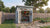 Light-gray Shed Liquidators Spokane backyard storage shed with open double doors, lawn equipment, and organized garden tools.