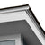 Close-up of a shed roof corner showing white trim, asphalt shingles, and textured wood siding.