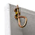 Close-up of a gold-colored metal gate latch attached to a wooden shed door.