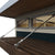 Close-up of a modern shed’s window with a wooden roof overhang, featuring metal support cables and sleek glass windows