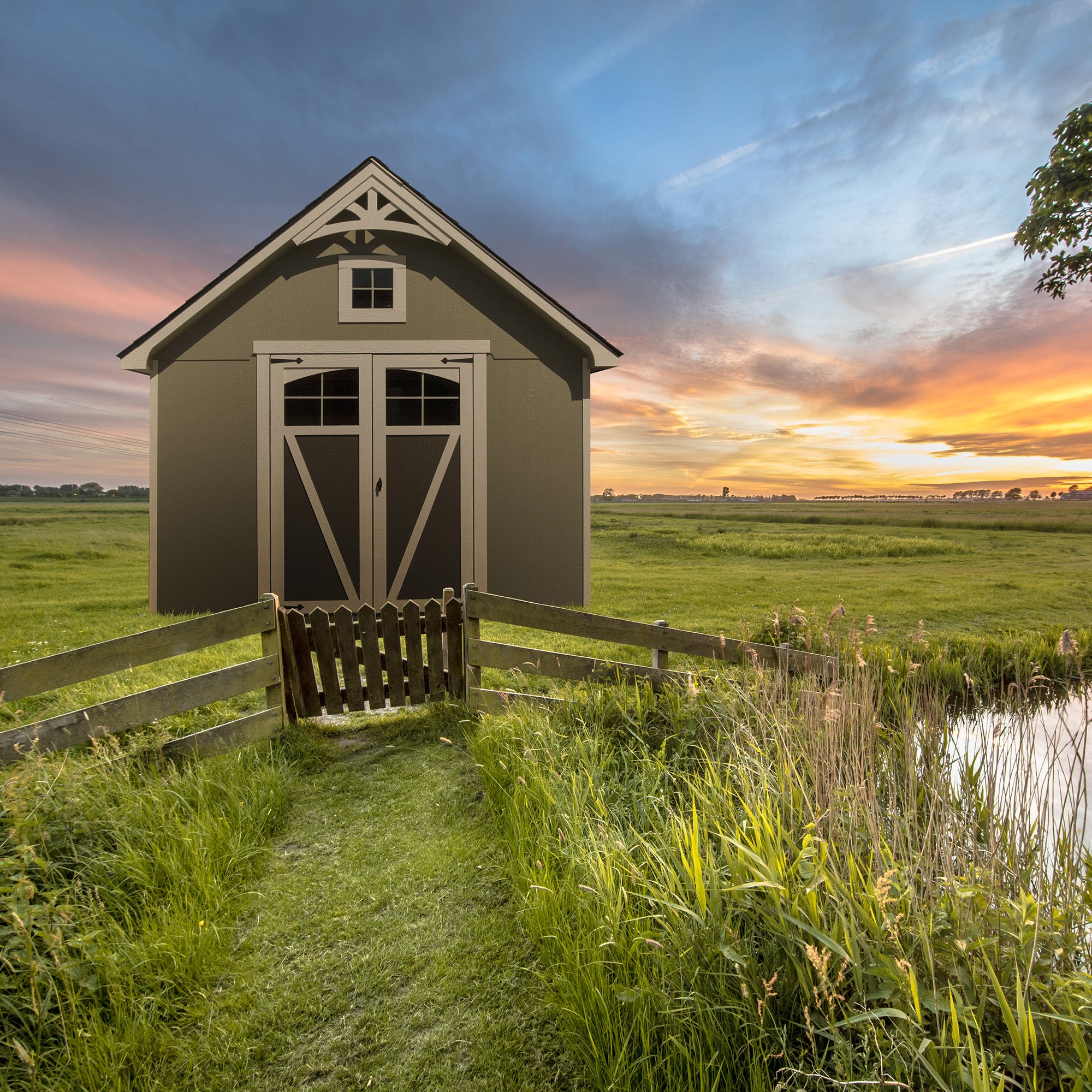 Storage shed in middle of the field with fence in front 